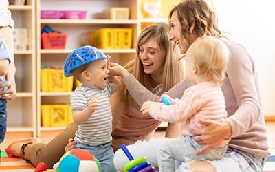 children and caregivers at play time links to Early Childhood Programs webpage